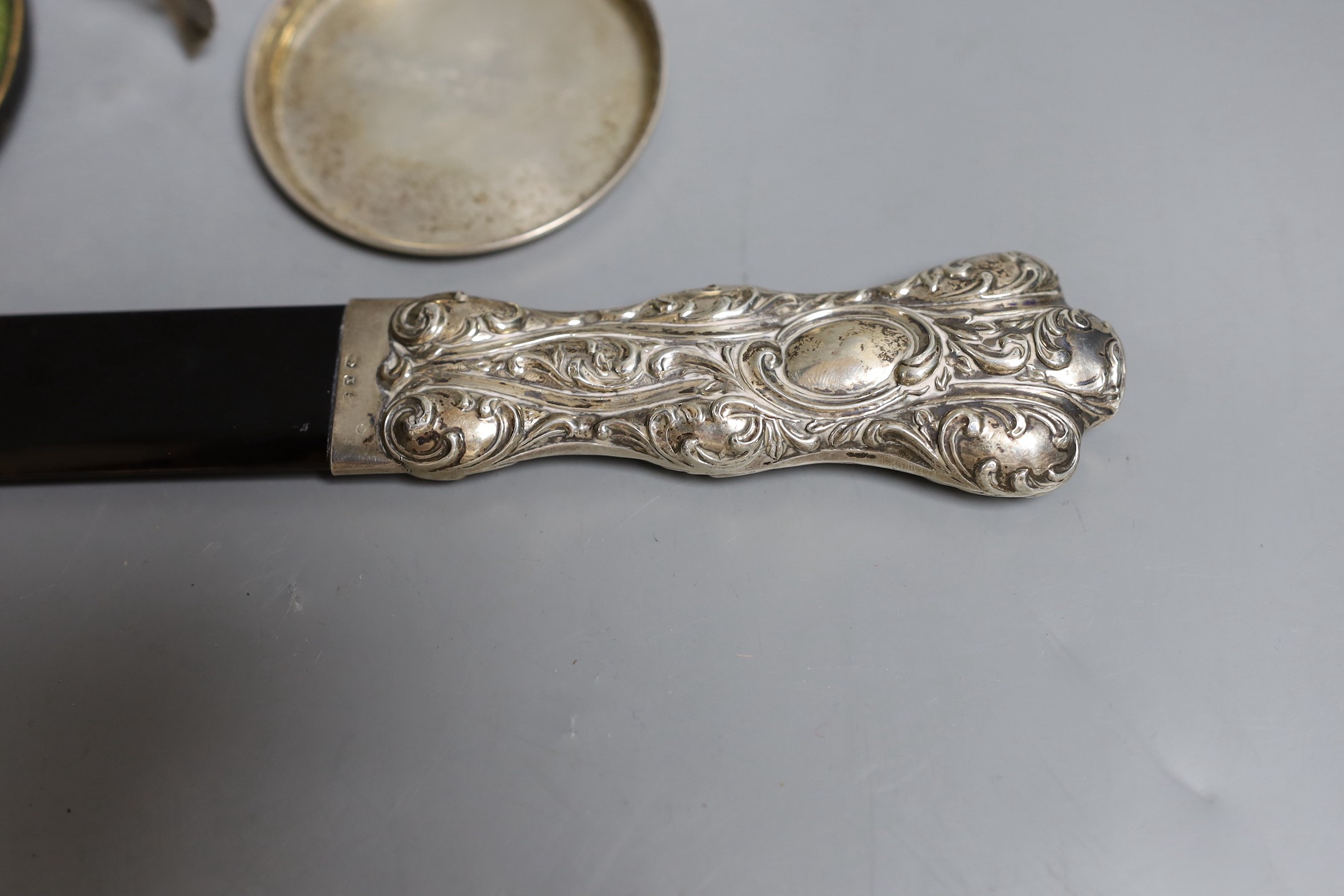 A late Victorian repousse silver mounted tortoiseshell page turner (chip), 39.6cm, a silver rattle, a silver the Irish Times pin tray, 800 standard model of a rose and a cased silver christening pair.